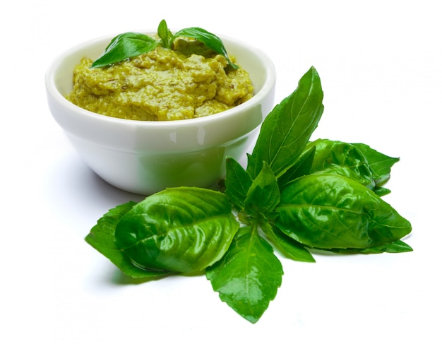 Salsa de pesto con albahaca sobre mesa blanca