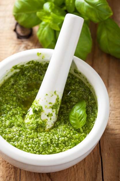 Foto salsa de pesto e ingredientes sobre fondo de madera