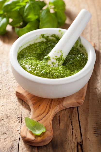 Foto salsa de pesto e ingredientes sobre mesa de madera