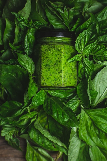 Salsa de pesto en un frasco de vidrio hojas de albahaca verde