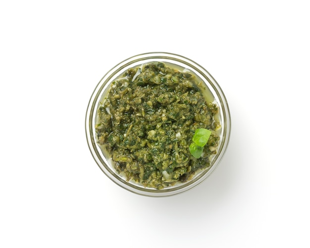 Salsa de pesto en un recipiente aislado en blanco