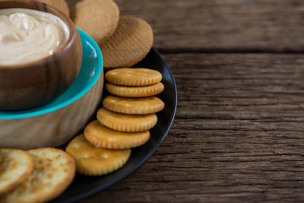 Salsa de queso con galletas en plato negro