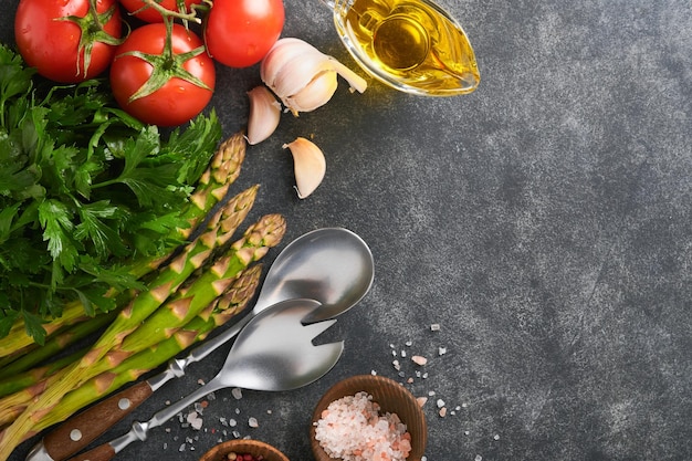 Salsa salsa tomate alho azeite pimenta sal e salada garfo e colher no fundo de cozimento de pedra preta Fundo de cozimento de alimentos Ingredientes para cozinhar fundo de alimentos Mock up