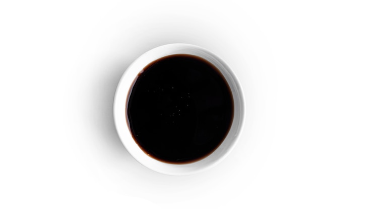Foto salsa de soja en una cacerola aislada en blanco.