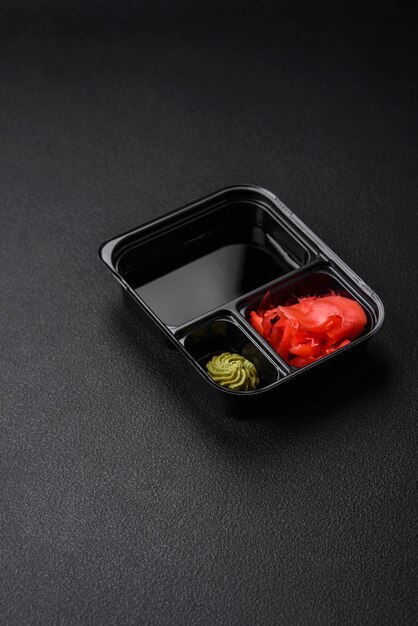 Salsa de soja con jengibre encurtido y wasabi en envases de plástico en porciones