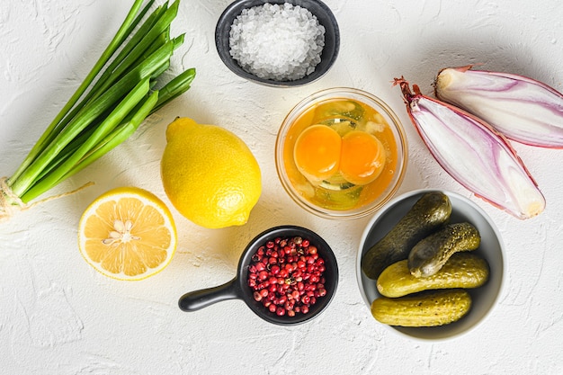 Foto salsa tártara ingredientes orgánicos crudos maduros alcaparras, pepinos, perejil, limón y huevos