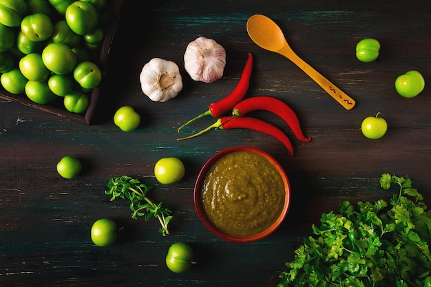 Salsa tkemali cocina georgiana tradicional ciruela cereza verde sobre una mesa de madera primer plano comida rústica fondo sin gente enfoque selectivo