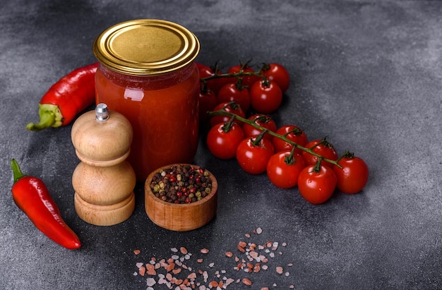 Salsa de tomate dulce picante con pimienta de ajo y hierbas en frascos de vidrio