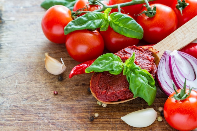 Salsa de tomate e ingredientes en el fondo de madera blanco