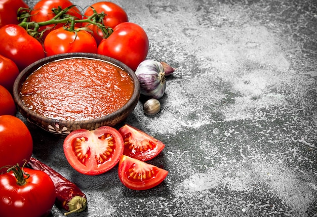 Salsa de tomate con especias y hierbas de mesa rústica.