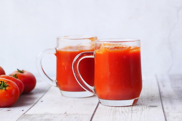 Salsa de tomate en un frasco con tomate fresco en la mesa