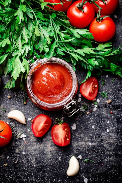 Salsa de tomate en un frasco de vidrio con perejil y ajo