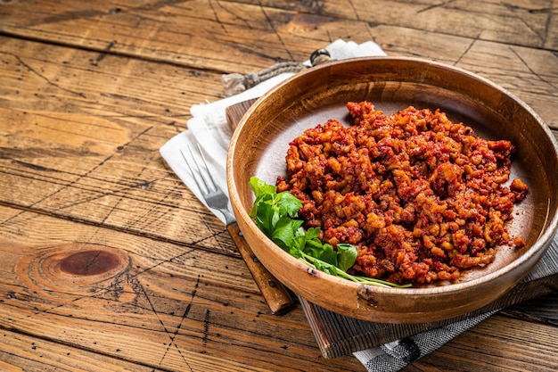 Salsa de tomate italiana tradicional boloñesa con carne picada en un plato de madera con hierbas Fondo de madera Vista superior Espacio de copia