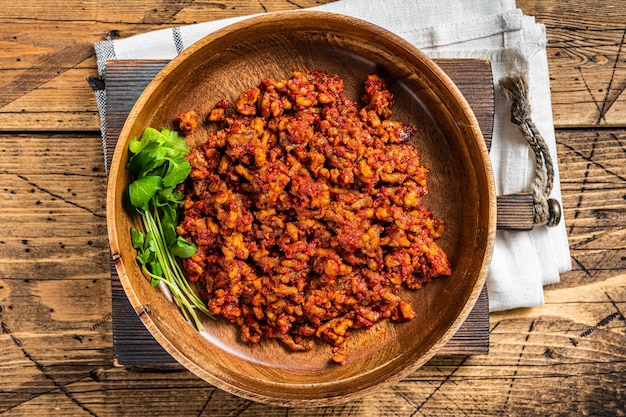 Salsa de tomate italiana tradicional boloñesa con carne picada en un plato de madera con hierbas Fondo de madera Vista superior