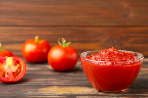 Salsa de tomate ketchup en un recipiente con tomates