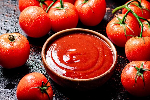 Foto salsa de tomate con una rama de tomates frescos