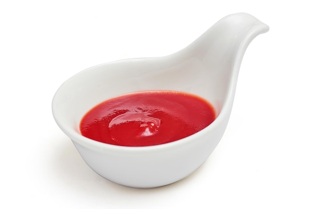 Salsa de tomate en una taza de salsa blanca en forma de cuchara aislada sobre fondo blanco Salsa de tomate utilizada para añadir sabores agridulces a los alimentos
