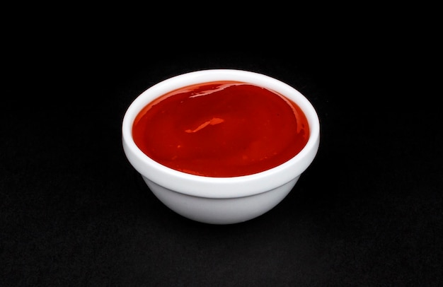 Salsa de tomate en un tazón blanco sobre fondo negro