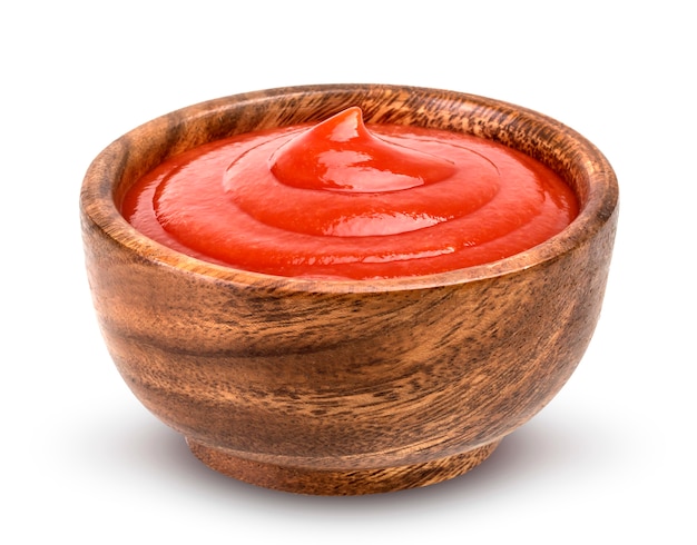 Salsa de tomate en un tazón de madera aislado sobre fondo blanco.