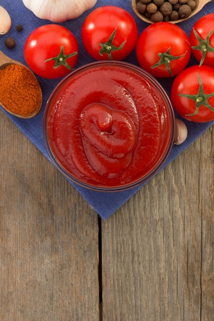 Foto salsa de tomate en un tazón sobre fondo de madera