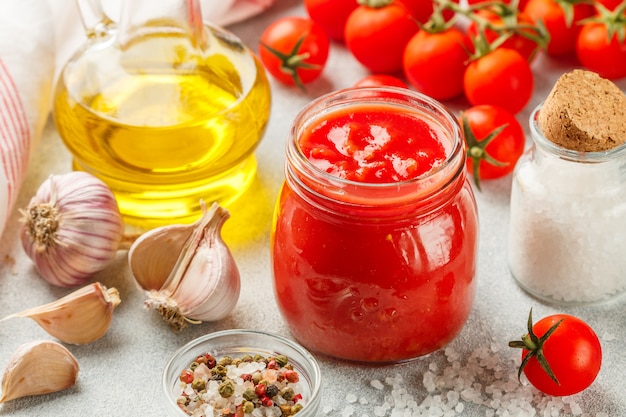 Salsa de tomate tradicional en un frasco de vidrio con ajo y especias.