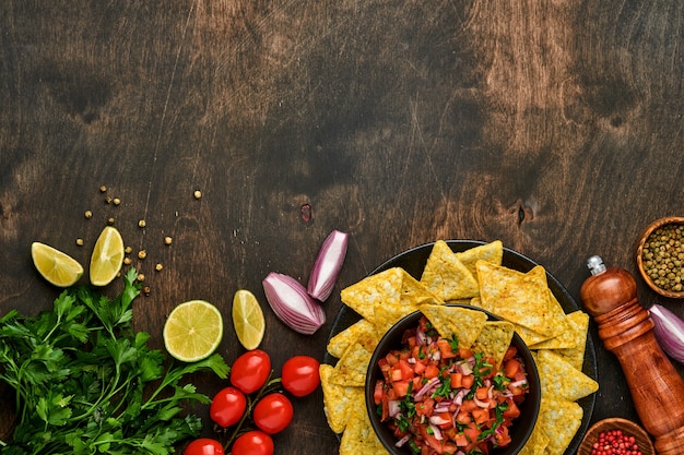 Foto salsa de tomate tradicional mexicana con nachos e ingredientes tomates, chile, ajo, cebolla