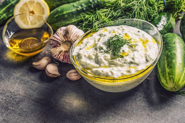 Salsa tzatziki en un tazón de vidrio eneldo pepino aceite de oliva limón y ajo.