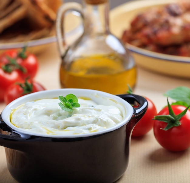 Foto salsa tzatziki tradicional en un tazón negro sobre una mesa