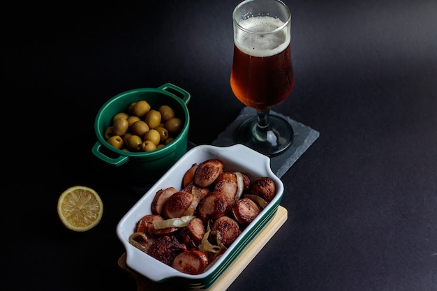 Foto salsicha alemã com azeitonas e cerveja artesanal