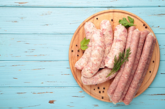 Salsicha crua na tábua com espaço de cópia.