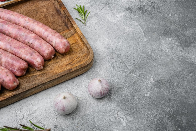 Salsicha crua para fritar, no fundo da mesa de pedra cinza, com espaço de cópia para texto