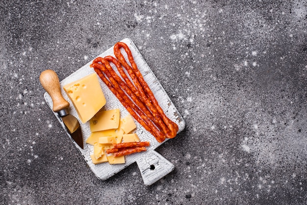 Salsicha de queijo e salame na placa de madeira