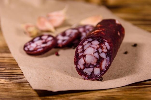 Salsicha de salame fatiado e alho em um papel de embrulho marrom