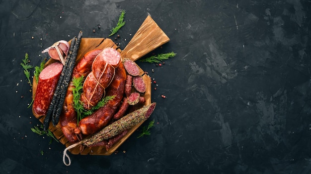 Salsicha Fuet salame cartão na placa da cozinha Em um fundo preto Vista superior Espaço livre para o seu texto