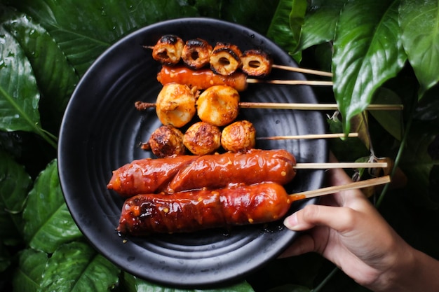 Foto salsicha grelhada com molho vermelho picante comida de rua