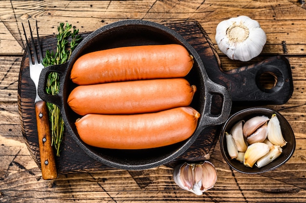 Salsichas bratwurst de carne de porco em uma panela.