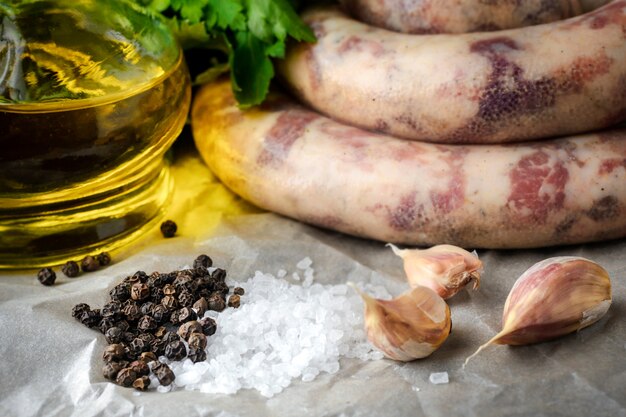 Salsichas caseiros, alho, salsa e azeite em cima da mesa.