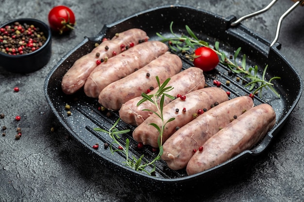 Salsichas cruas com especiarias e alecrim. Fundo de receita de comida. Fechar-se.