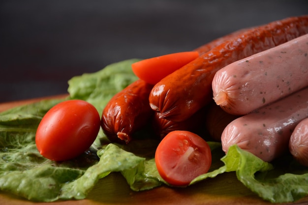 Foto salsichas cruas com tomate para churrasco.