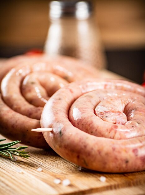 Foto salsichas cruas em um fundo de madeira