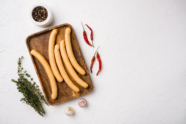 Salsichas de cachorro-quente de carne fresca sobre fundo de mesa de pedra branca vista de cima plana com espaço de cópia para texto