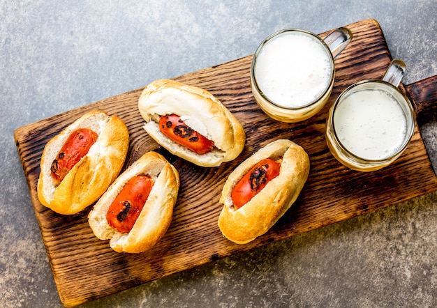 Salsichas de cerveja em pães e canecas de cerveja