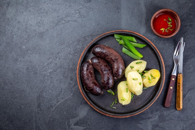 Foto salsichas de sangue morcilla espanholas e argentinas com batatas e molho de chile