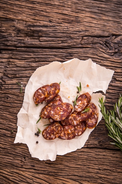 Salsichas. Salsicha defumada. Chouriço com especiarias de alecrim vegetal e utensílios de cozinha.