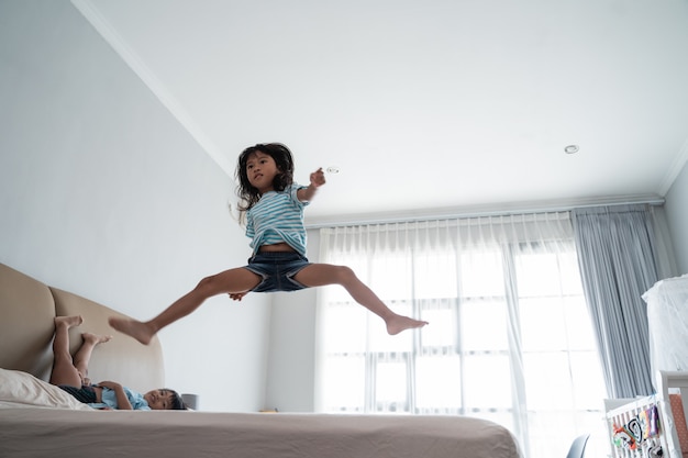 Saltando joven en la cama