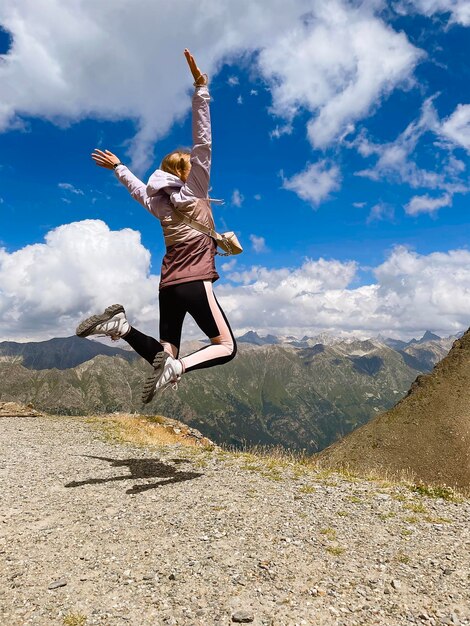 saltando en la montaña contra el cielo