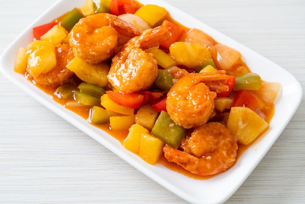 Salteado agridulce con camarones fritos en el plato - Estilo de comida asiática
