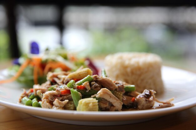 Salteado de pollo y albahaca servido con arroz