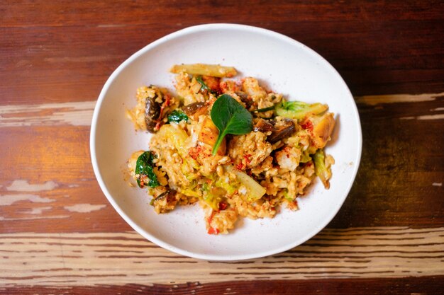 Salteado de verduras con arroz y huevo Cocina oriental panasiática en mesa de madera