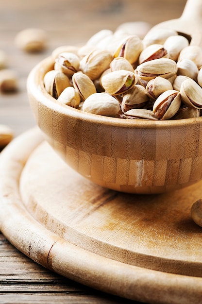 Salth pistachos en la mesa de madera